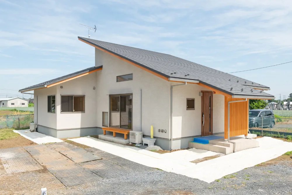 シャープさと雄大さを兼ね備えた平屋の外観は、左官の外壁仕上げで木部がアクセント。